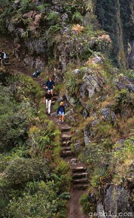 Visitors descending the steep stairway leading from the top of Huayna Picchu mountain, Peru