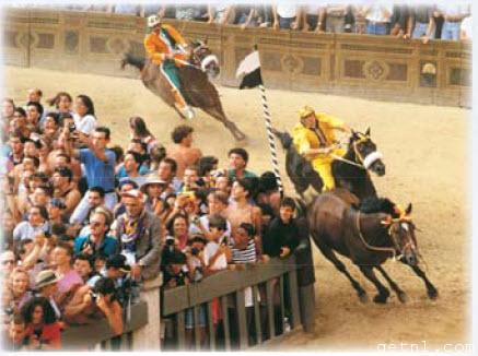 ABOVE A crush of spectators watching the race from behind fences at the Siena palio