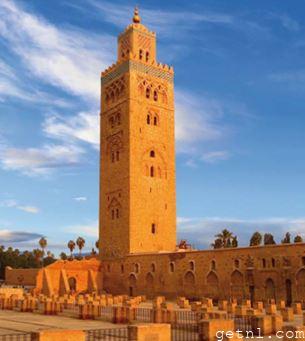 Delicately carved Islamic stone- and tilework ornamentation on the Koutoubia Minaret, bathed in late-afternoon sunlight, Morocco