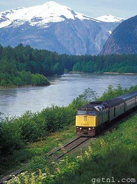 The Canadian passing by a lake and lush greenery on its Toronto– Vancouver route
