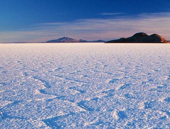 The expansive, pristine salt plains of the Salar de Uyuni, Bolivia, drenched in evening sunlight