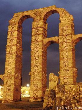 The remains of the towering Acueducto de Los Milagros, illuminated at night
