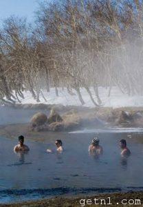 A group of visitors enjoying the natural hot springs in the freezing winter at Kamchatka, Russia