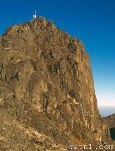 The barren rocky summit of Mount Wilhelm, Papua New Guinea, set against a brilliant blue sky