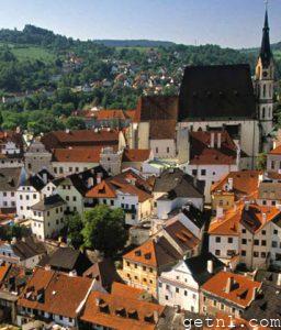 The charming city of Český Krumlov beside the Vltava river, with idyllic wooded hills and fields in the background, Czech Republic